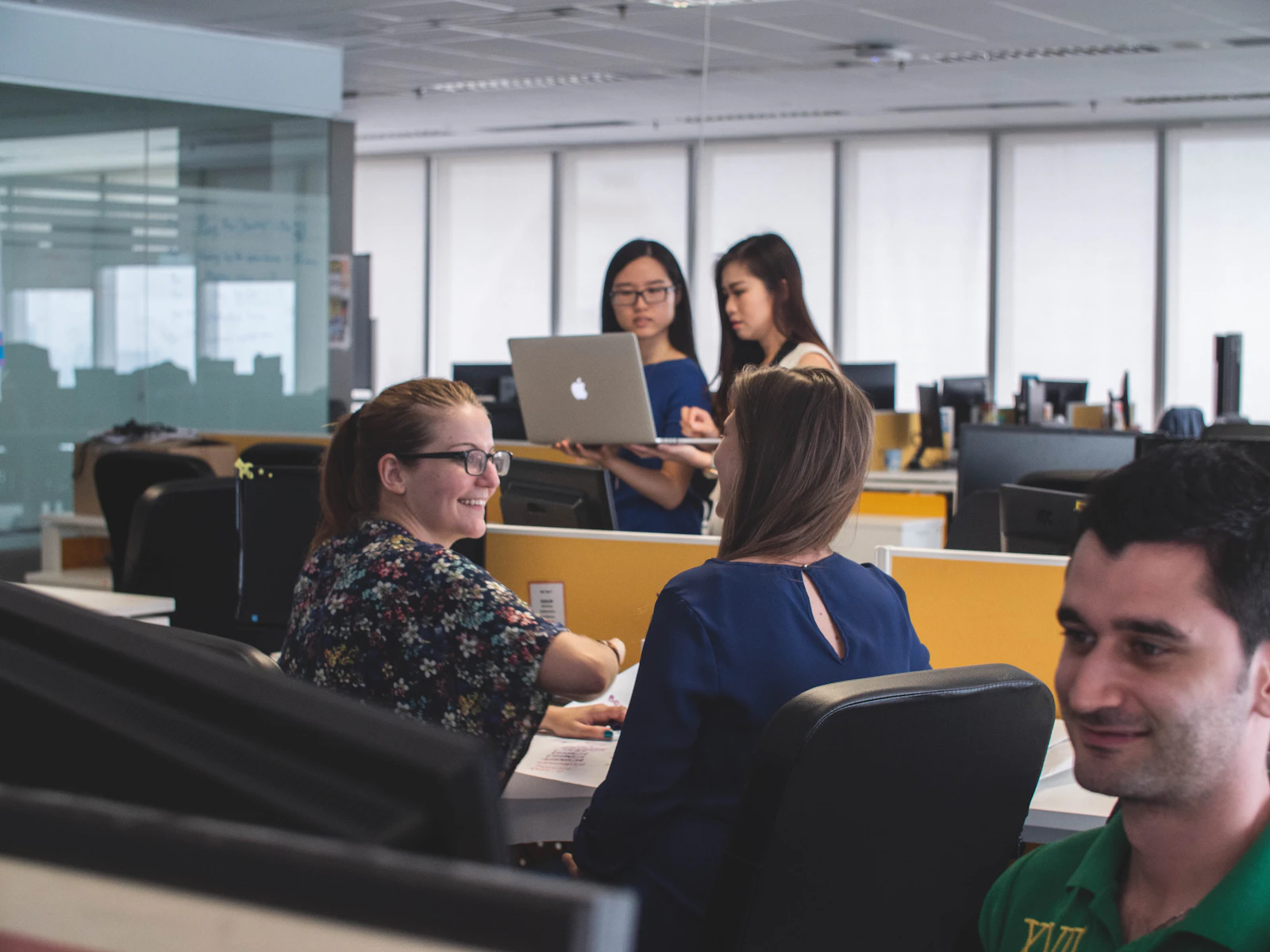 Smiling colleagues collaborating in a bright office